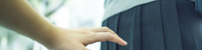 女性のお尻を触ろうとする男性